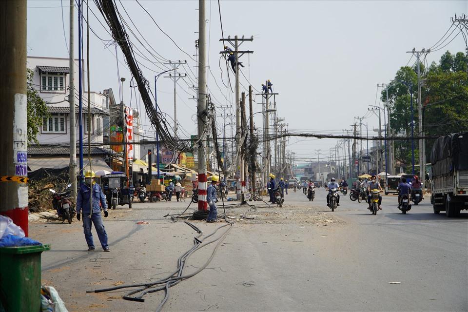 Nhân viên điện lực di dời các trụ điện cũ trên đường Đặng Thúc Vịnh.  Ảnh: Minh Quân