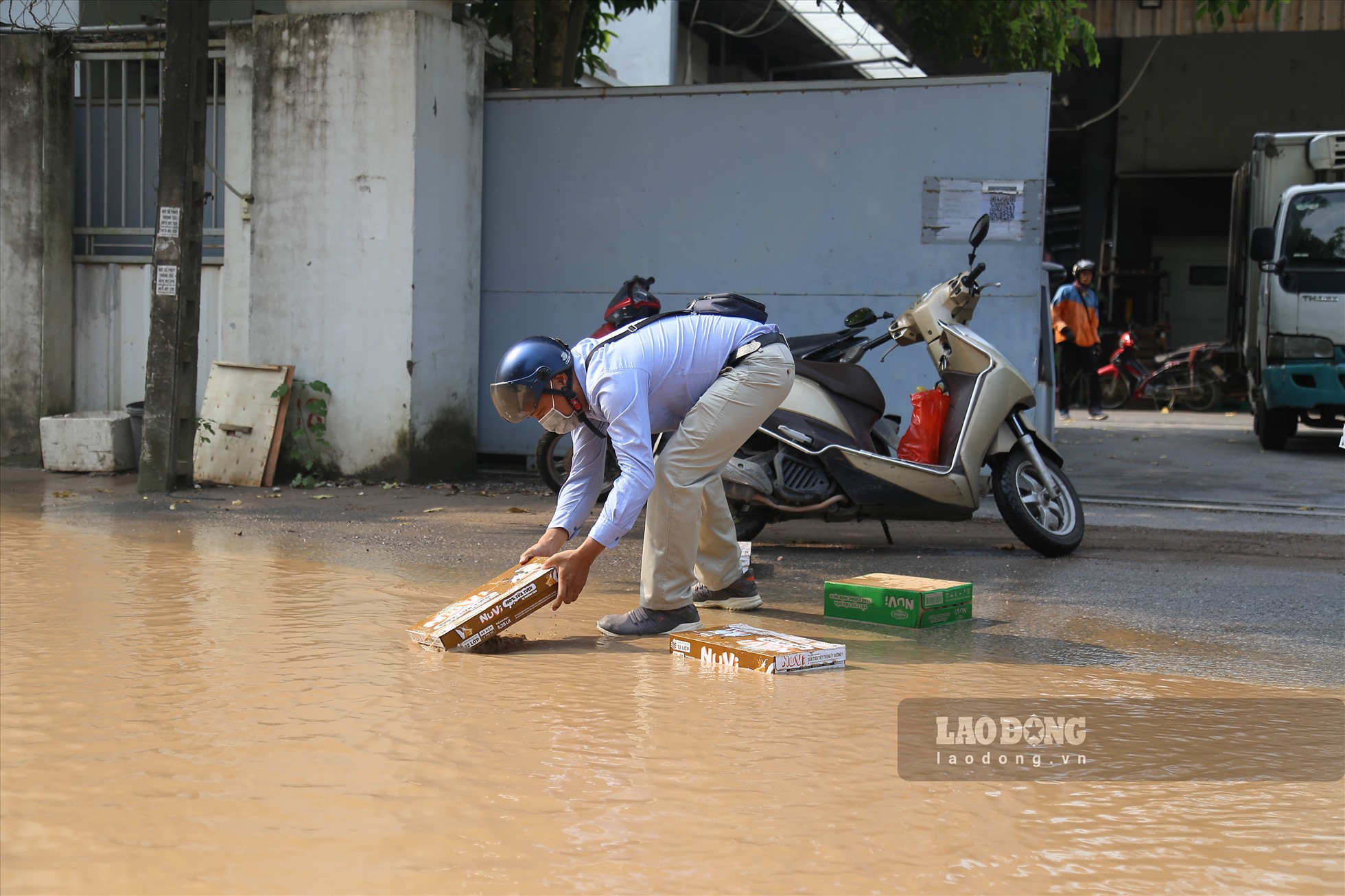 Người dân làm rơi đồ sau khi đi trúng vào ổ gà.