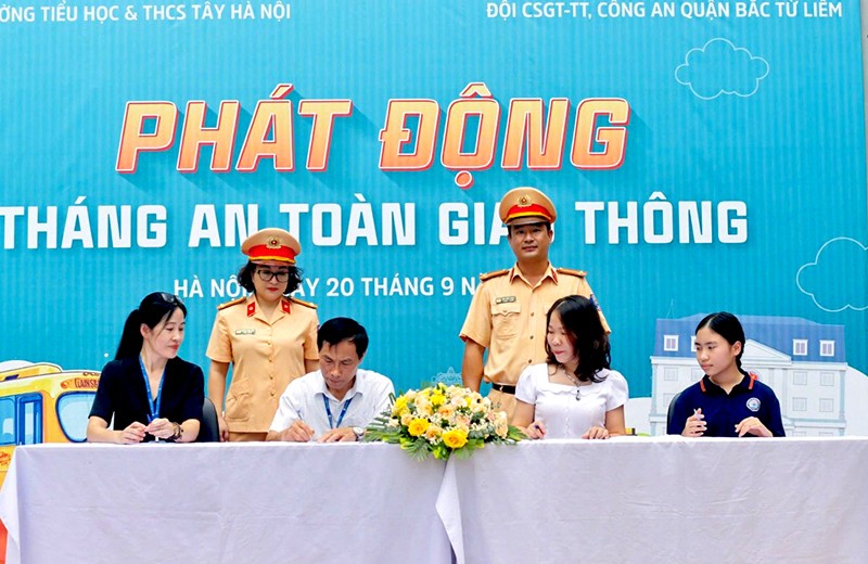 Đại diện Công an quận, giáo viên, phụ huynh, học sinh tổ chức ký cam kết chấp hành Luật Giao thông đường bộ tại trường Tiểu học Cổ Nhuế 2B