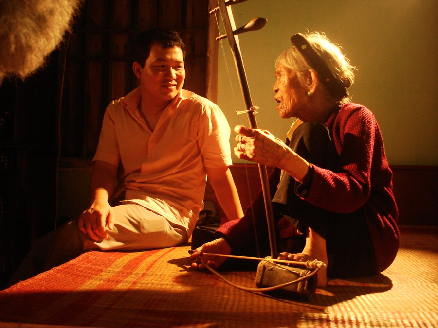 Đạo diễn Lương Đình Dũng trò chuyện cùng nghệ nhân Hà Thị Cầu trong phim 'Xẩm đỏ'. Ảnh cắt từ phim.