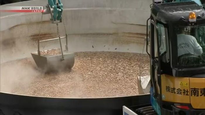 2 máy xúc cỡ nhỏ múc món canh cho vào các thùng chứa nhỏ hơn để phục vụ cho những du khách đang xếp hàng chờ đợi