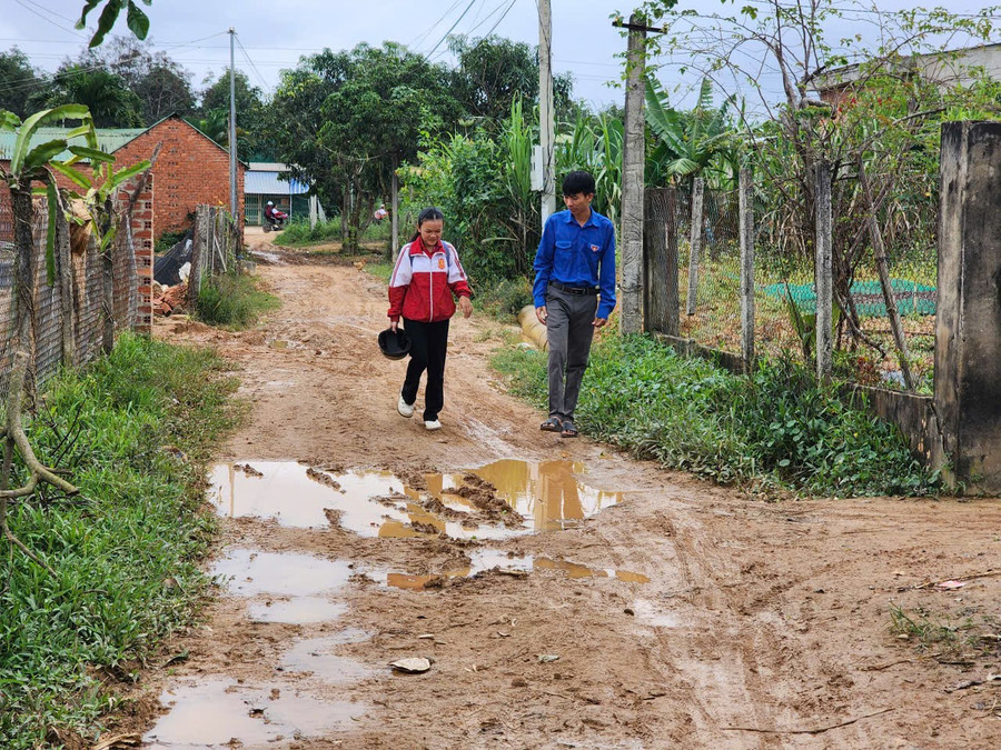 Anh Hoàng Vĩnh Hải – Bí thư Chi đoàn buôn Ea Rớt (áo xanh) đến từng nhà tuyên truyền bà con đi học chữ. (Ảnh: TT)