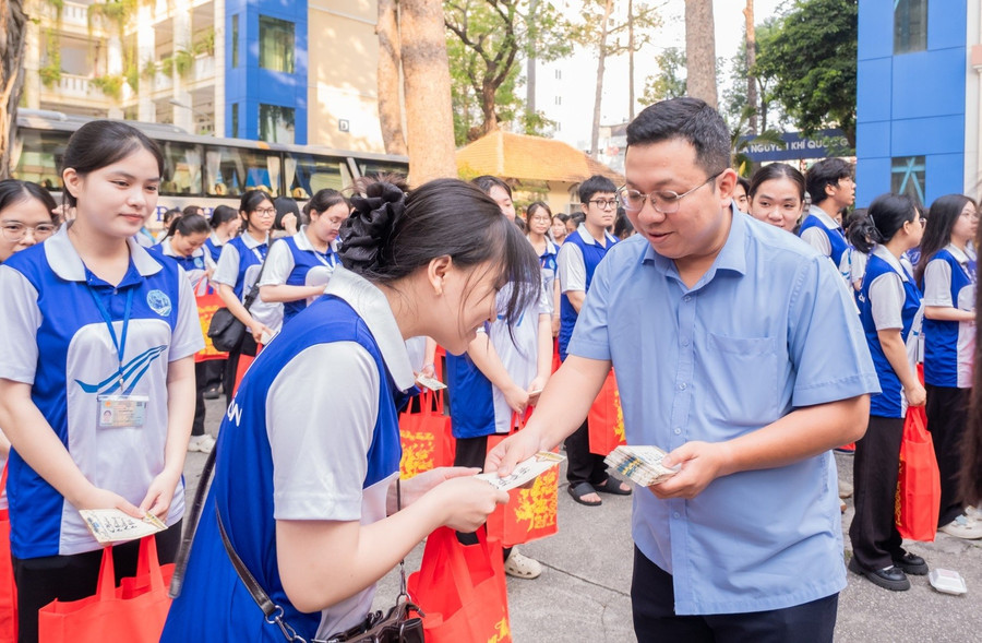 Lãnh đạo Trường Đại học Sài Gòn lì xì và tặng quà cho sinh viên trước giờ lên xe về quê. Ảnh: SGU
