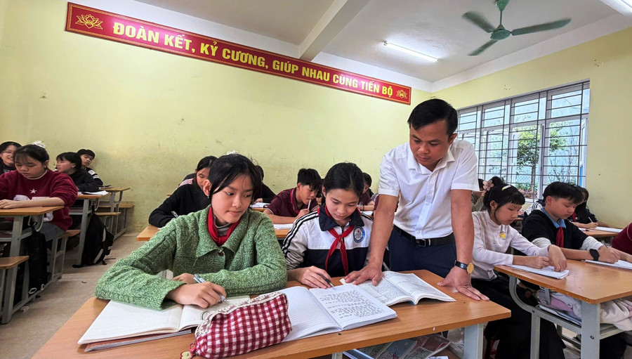 Thầy giáo Hà Văn Dàn và học sinh của mình ở Trường TH&THCS Mường Lát. Ảnh: Thế Lượng