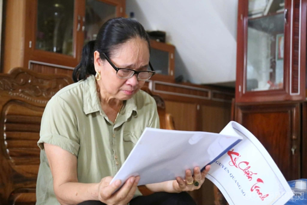 Bà Hoa xúc động khi đọc những trang nhật ký của người cha viết từ chiến trường. ảnh: Kim Long clo_br_1.jpg