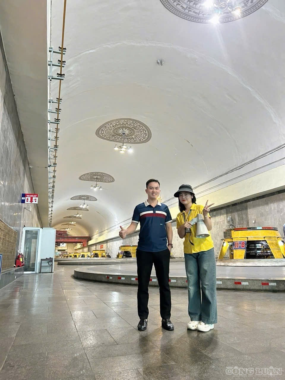 Chị Lê Thị Thanh Hằng - hướng dẫn viên tại điểm khu vực nhà máy Thuỷ điện Hoà Bình (bên phải) cùng du khách lưu lại hình ảnh trong gian máy, phía sau là dãy tổ máy đặt sâu trong lòng núi clo_br_img-8344.jpg